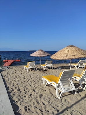 Privatstrand, Liegestühle, Sonnenschirme, Strandtücher