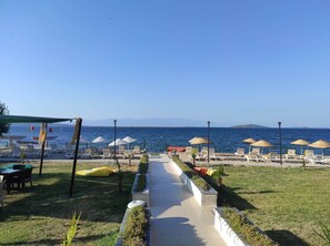 Praia particular, espreguiçadeiras, guarda-sóis, toalhas de praia 