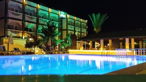 A hotel with a swimming pool, outdoor seating, and a well-lit facade. - Cunda Basel hotel (Ayvalik)