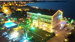 A hotel with a swimming pool, a parking lot, and a view of the sea. - Cunda Basel hotel (Ayvalik)