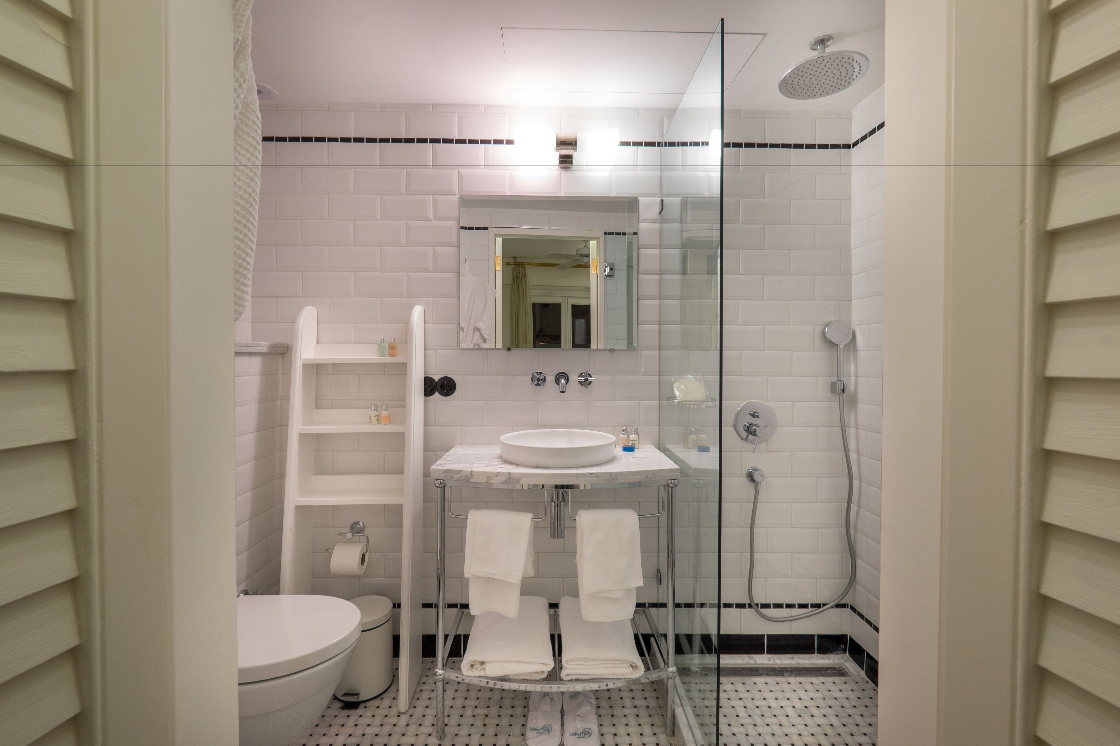 Et badeværelse med toilet, vask og brusekabine.