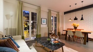 A modern living room with a sofa, a dining table, and a black marble coffee table. - Pera Neuf (Istanbul)