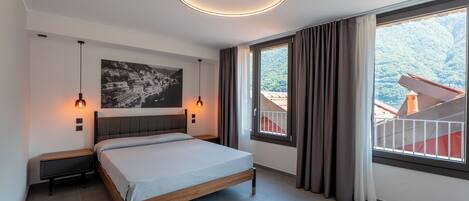 A modern bedroom with a bed, two bedside lamps, a ceiling light, a large window with curtains, and a cityscape painting on the wall.