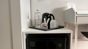 A compact kitchenette with a microwave, a coffee maker, and a water bottle. - Avec Moi Roma (Rome)
