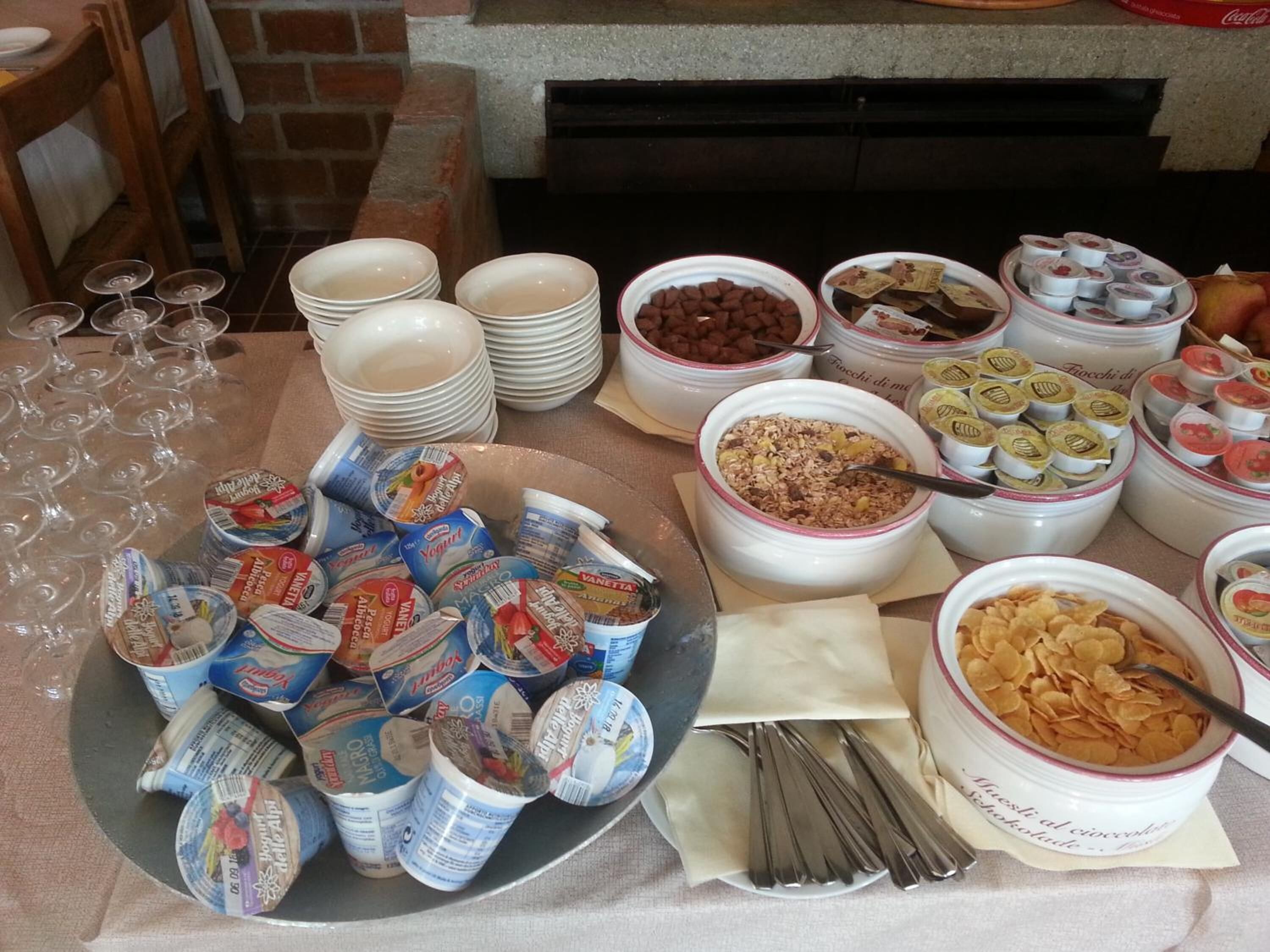 Un bufet amb diferents aliments, com ara iogurt, cereals i aperitius.