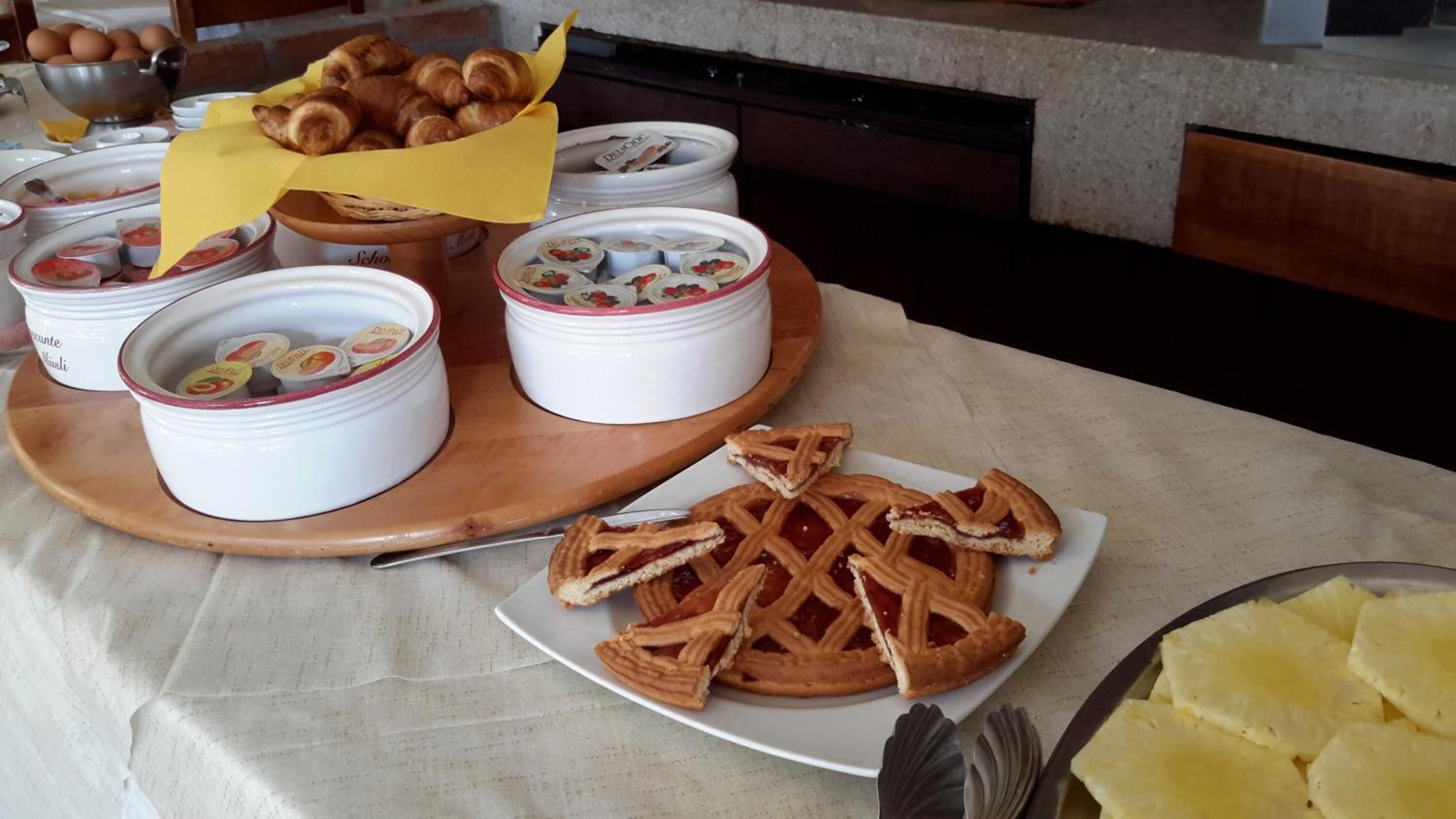 Ein Frühstücksbuffet mit Gebäck, Marmeladen und einem Teller Waffeln.