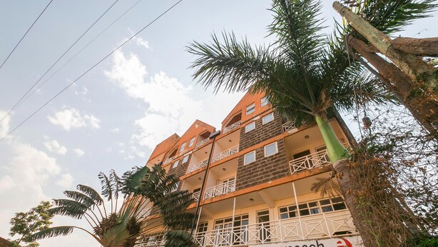 Edifício com vários andares e varandas, com uma placa indicando 'easyyoach', serviços de reserva e estacionamento.