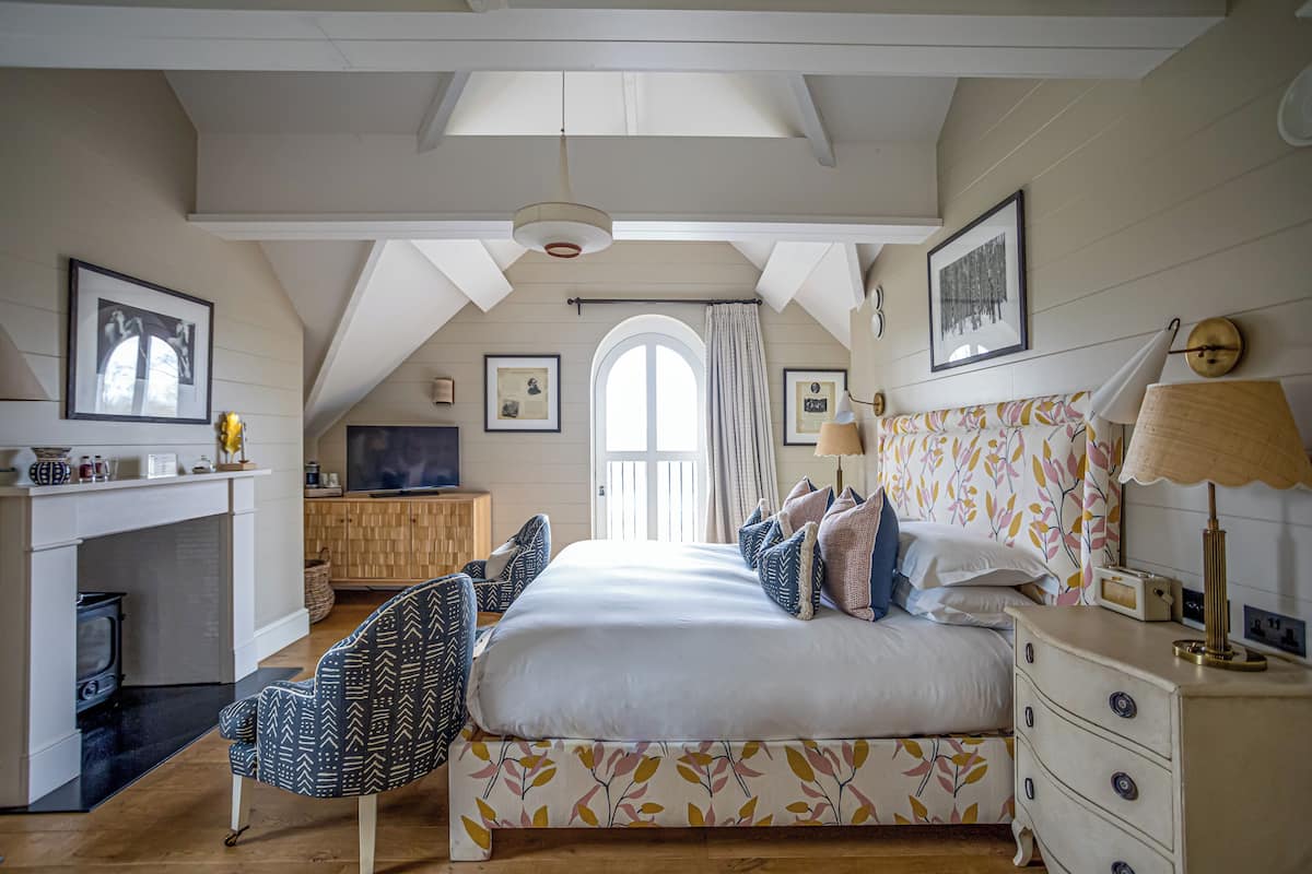 A bedroom with a bed, a desk, a chair, a dresser, and a television.