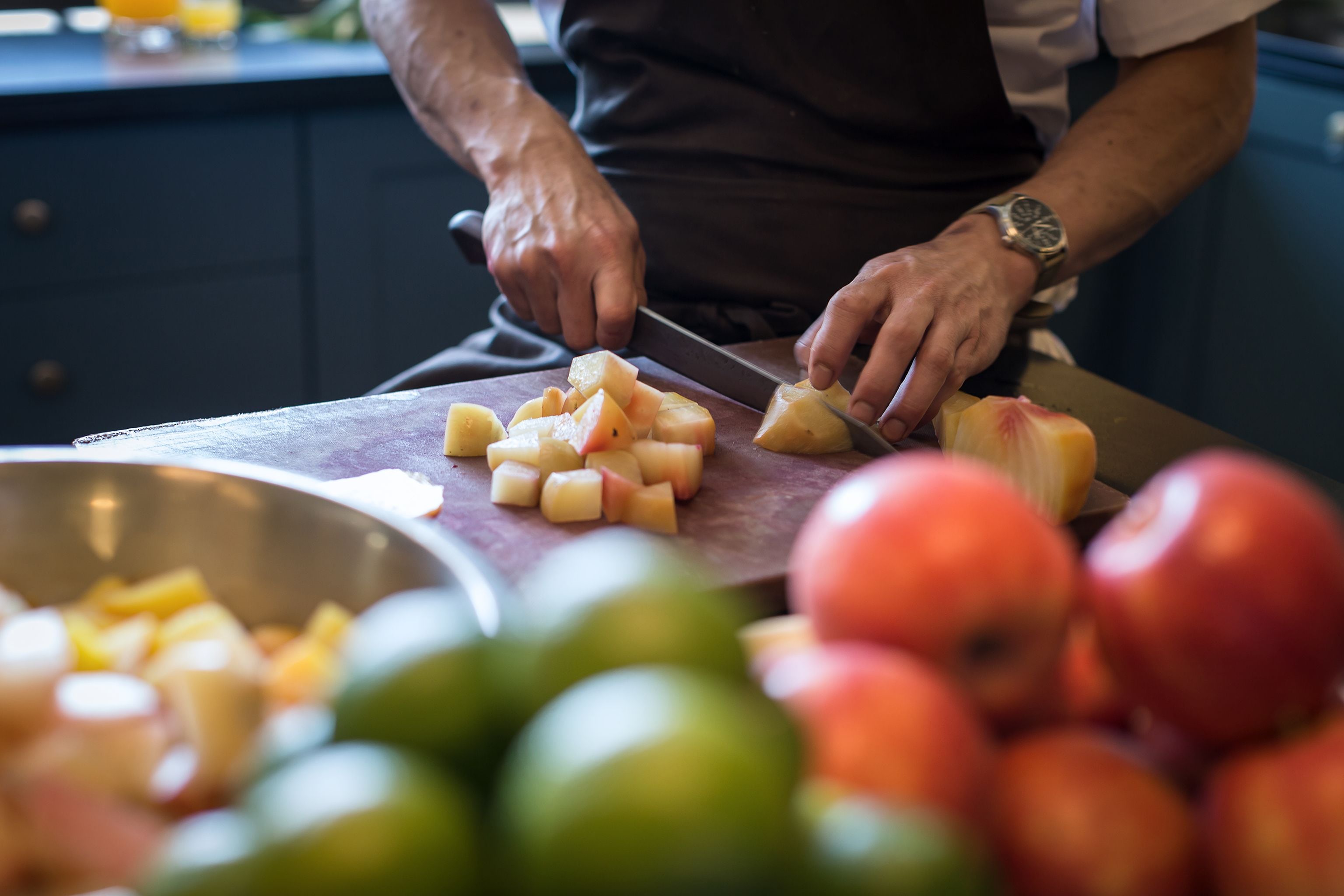 A person chopping potatoes on a cutting board.