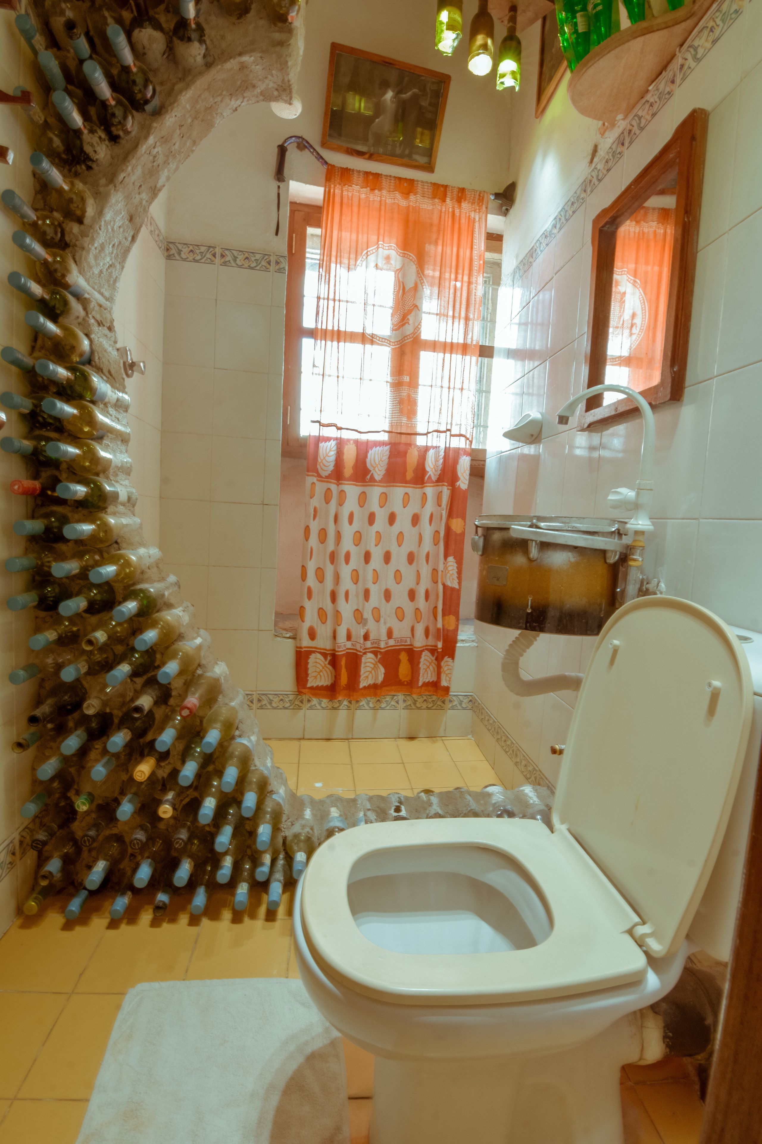 Un baño con inodoro, ducha y lavabo. Hay una cortina con estampado de lunares.