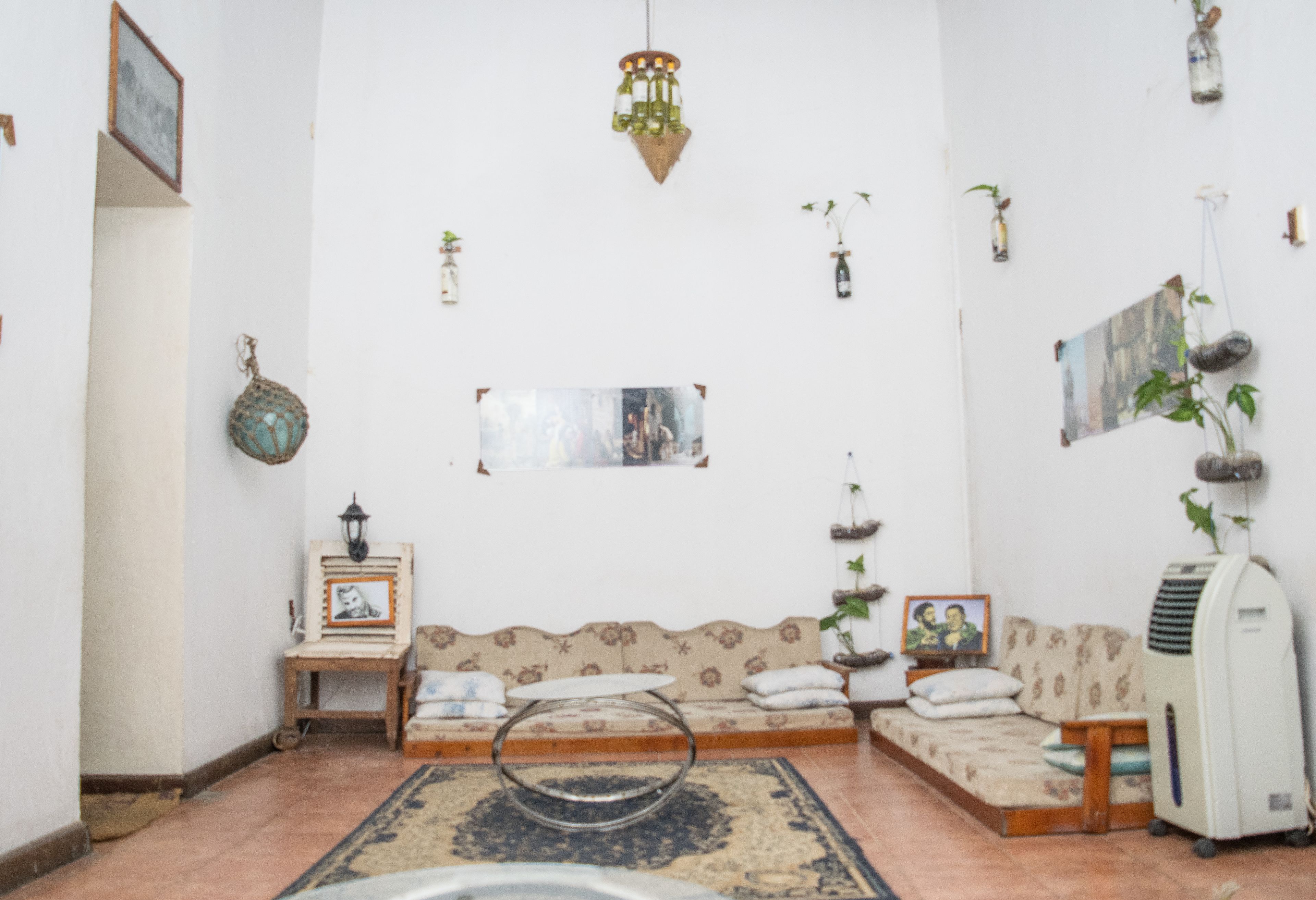 A living room with a sofa, a small table, a decorative rug, and a hanging light fixture.