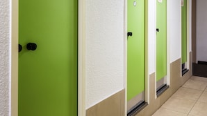 A row of green doors with white walls and beige floors, each marked with a WC sign. - hotelF1 Tours Nord (Tours)