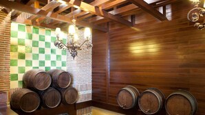 A wine cellar with wooden barrels and a checkered wall. - Hotel Azofra (Burgos)