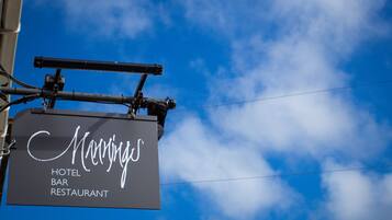 A sign for a hotel bar and restaurant with the name 'Manning's' in cursive font.