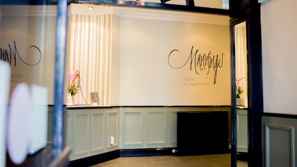 Zona de recepción de un hotel con un cartel que dice "Mannings Hotel & Apartments".