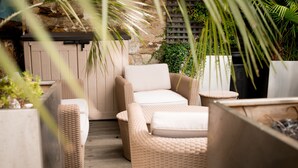 Muebles de mimbre con cojines en un jardín.