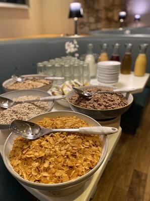 A buffet table with various food items including cereal, chocolate, and other snacks. - Mannings Hotel (Truro)