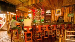 A bar with wooden walls and a variety of bottles. There are wooden chairs and a bar counter. - Magharibi Garden Hotel (Kisii)