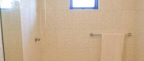 A bathroom with a sink, a mirror, a towel rack, and a window.