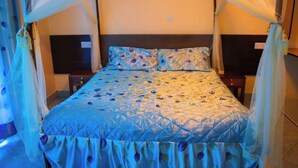 Una cama con dosel, cabecera y mesita de noche.