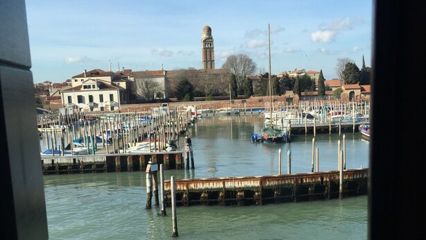 A marina with boats docked, a tower in the background, and a clear sky. - Harry's Guest House (Venice)