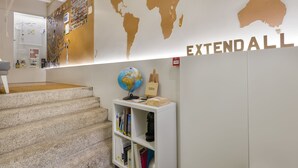 A staircase leading to a room with a world map on the wall, a globe, and a bookshelf. - YOUROPO - ExtendALL (Porto)
