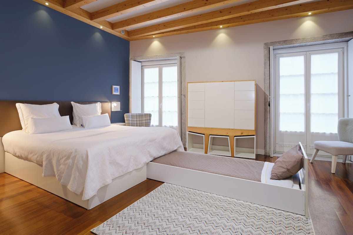A bedroom with a large bed, a desk, and a chair.