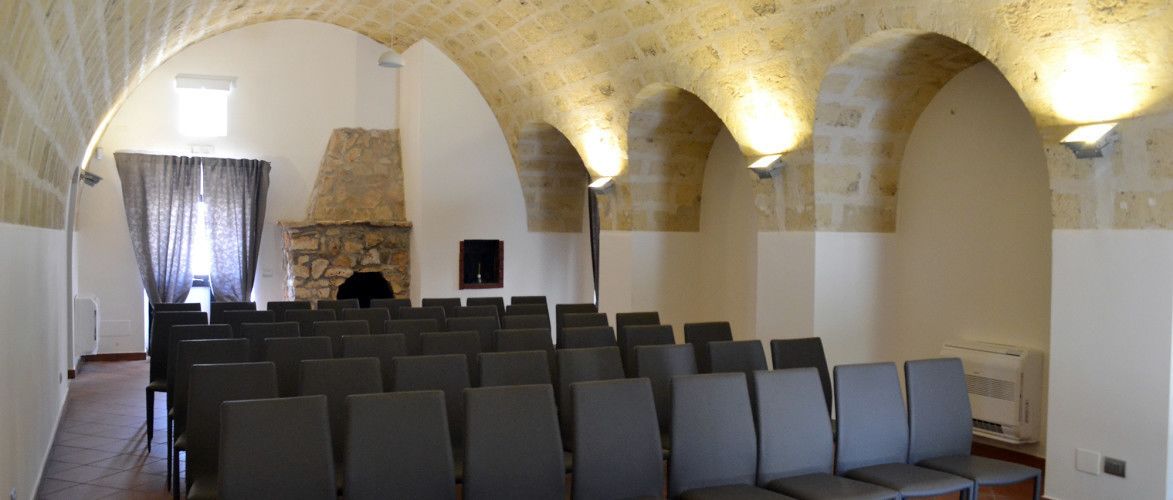 Interior de iglesia con hileras de bancas, una chimenea de piedra y techos abovedados.