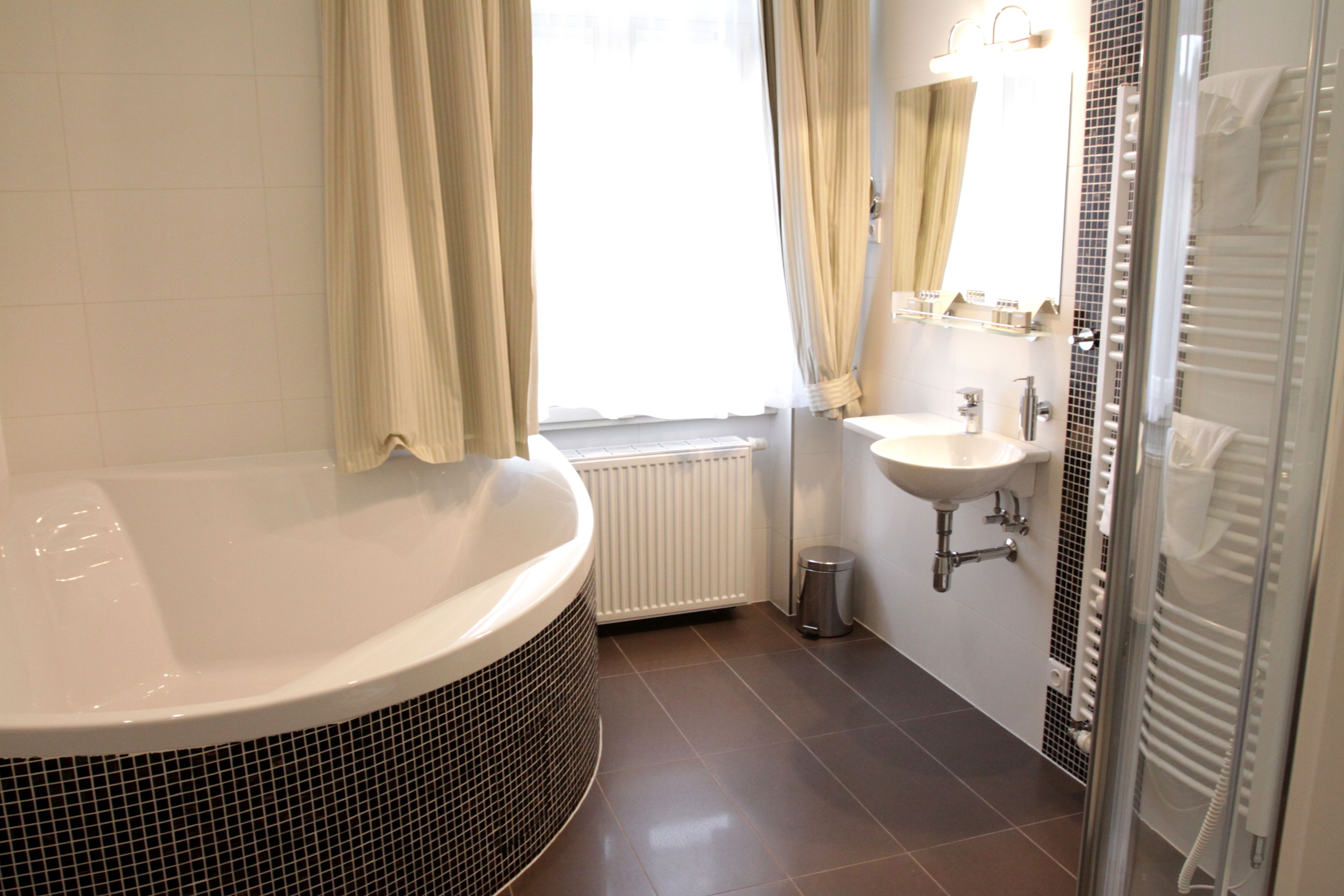 Une salle de bain moderne avec une baignoire sur pieds, un lavabo et un espace douche.