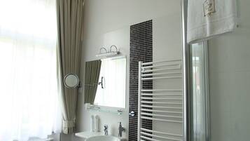 A modern bathroom with a sink, mirror, and towel rack.