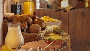 Een ontbijtbuffet met brood, kaas, ham en een melkkruik.