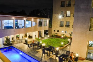 A hotel with a swimming pool, outdoor seating, and a well-lit courtyard. - Decale Jewel Stone Hotel (Nairobi)