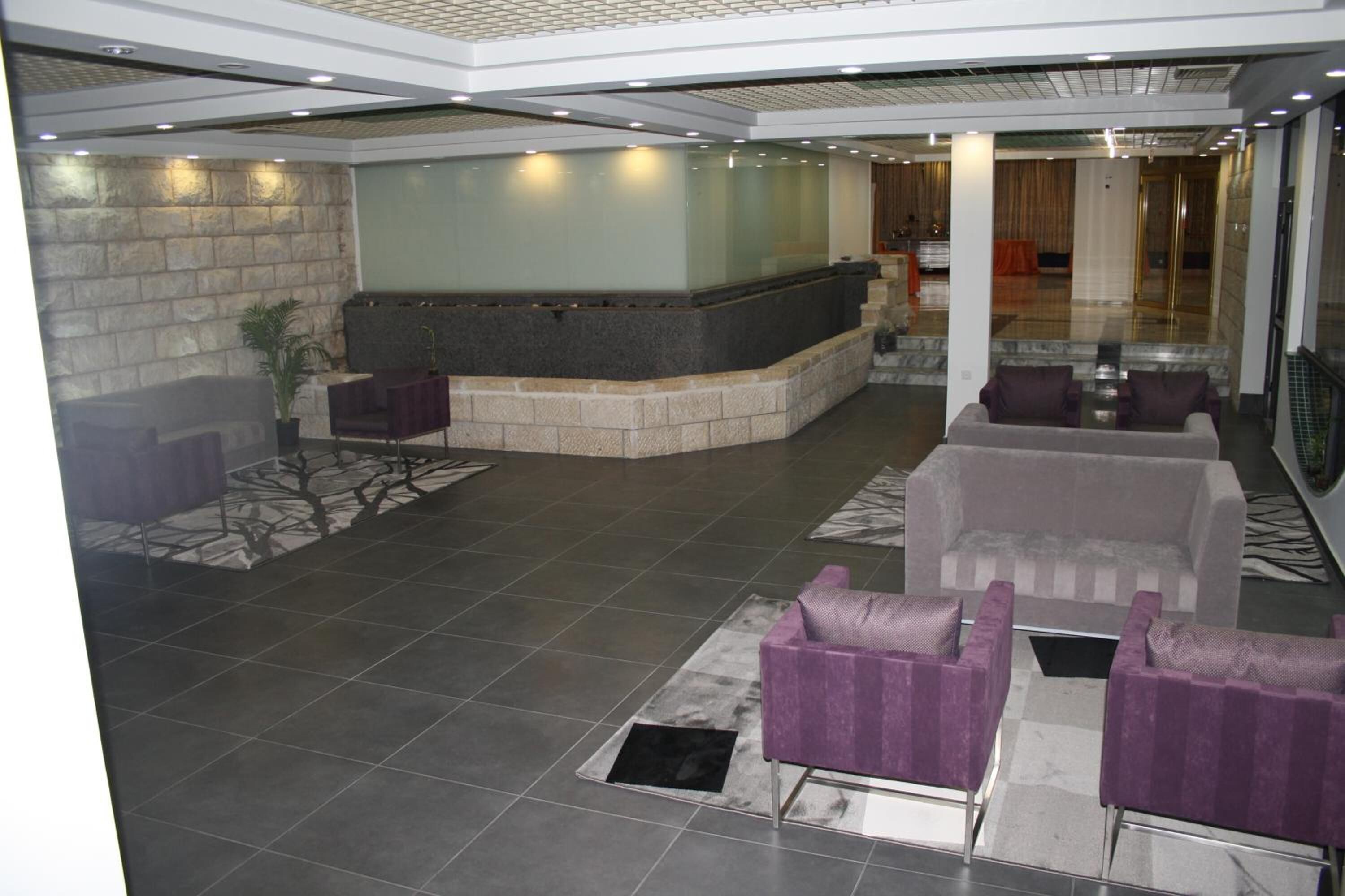 Eine Lobby mit einer Rezeption, einer Sitzecke und einer Steinwand.