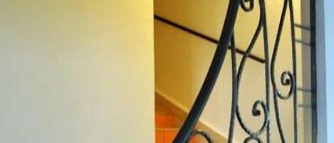 Una escalera con barandillas de metal ornamentadas y peldaños de madera.