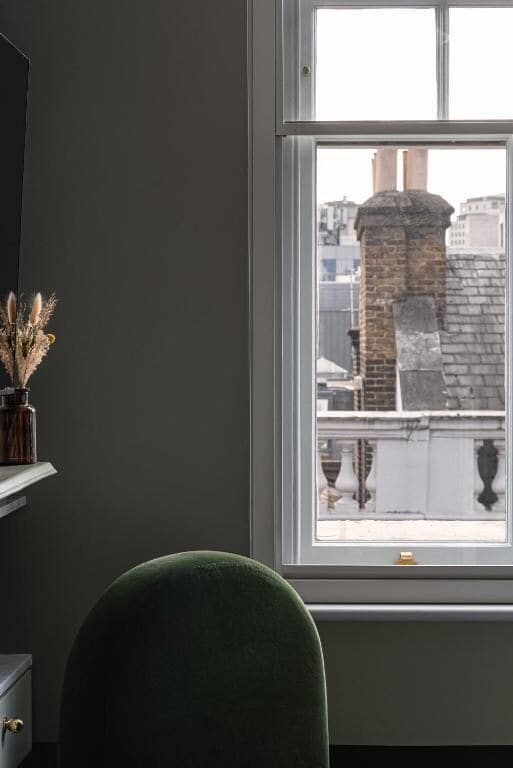 A room with a window overlooking a brick building.