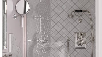 Un baño moderno con cabina de ducha de vidrio, inodoro de pared y lavamanos doble con encimera de mármol.