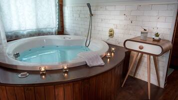 A bathroom with a wooden vanity, a white bathtub, and a small potted plant on the vanity.