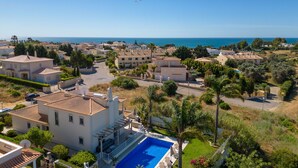 Zona residencial costera con piscina, casas y vista despejada al mar.