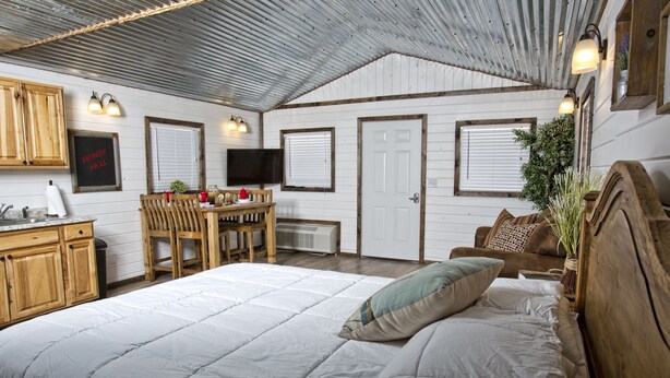 Une chambre à coucher avec un grand lit, des meubles en bois, un bureau et un téléviseur.