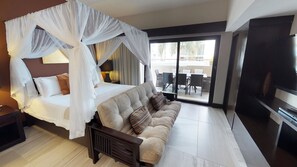 Una habitación de hotel moderna con cama, sofá, televisión y balcón con mobiliario exterior.