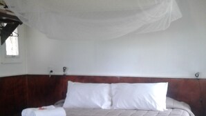 A bed with a canopy, a sofa, and a patterned rug. - Teukava Beach Oasis (Ha'atafu)