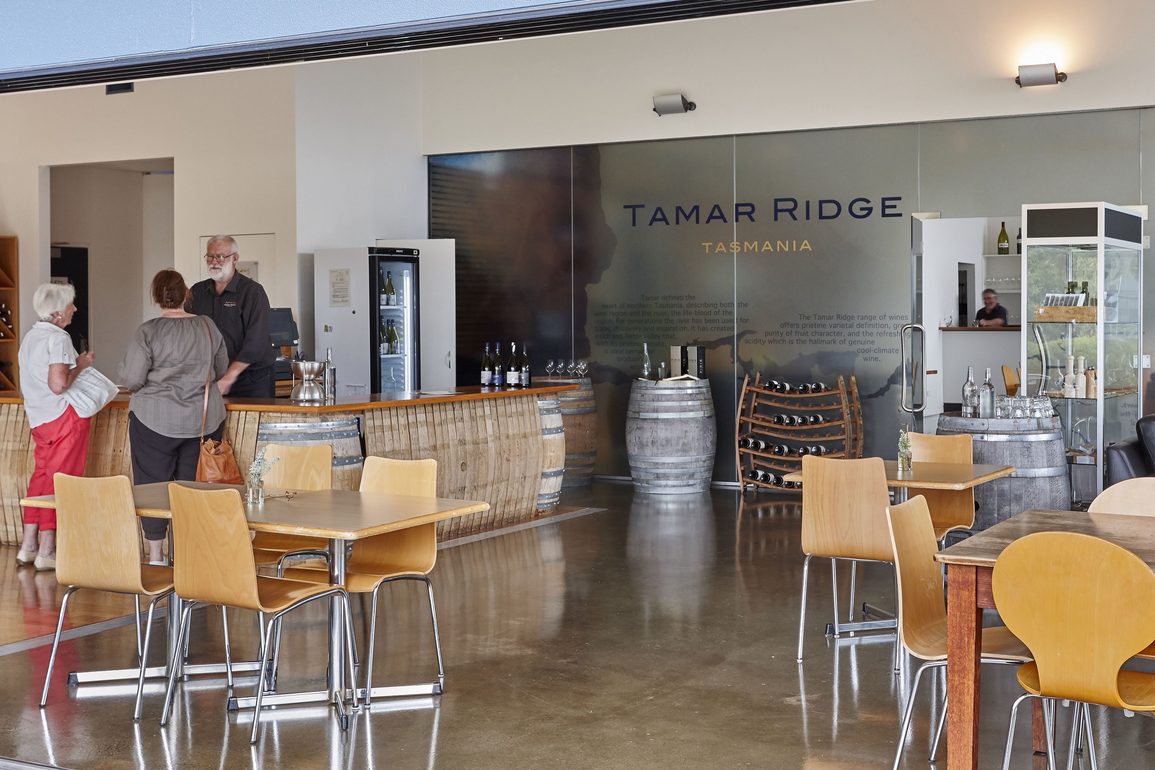 En restaurang med en bardel, trästolar och en stor skylt med texten ”Tamar Ridge Tasmania”.
