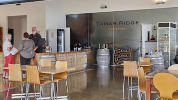 En restaurang med en bardel, trästolar och en stor skylt med texten ”Tamar Ridge Tasmania”.