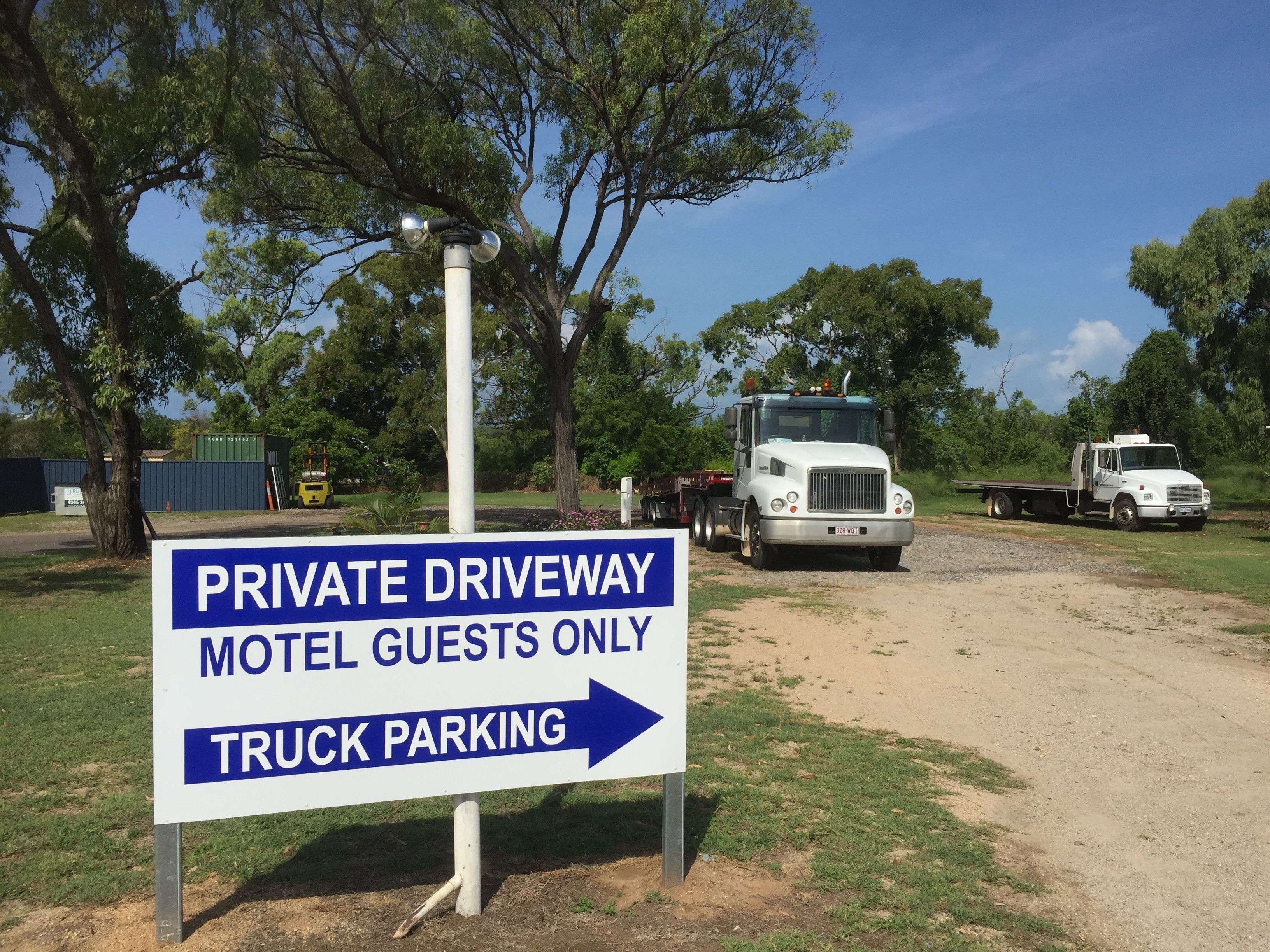 A sign indicating a private driveway for motel guests with truck parking.