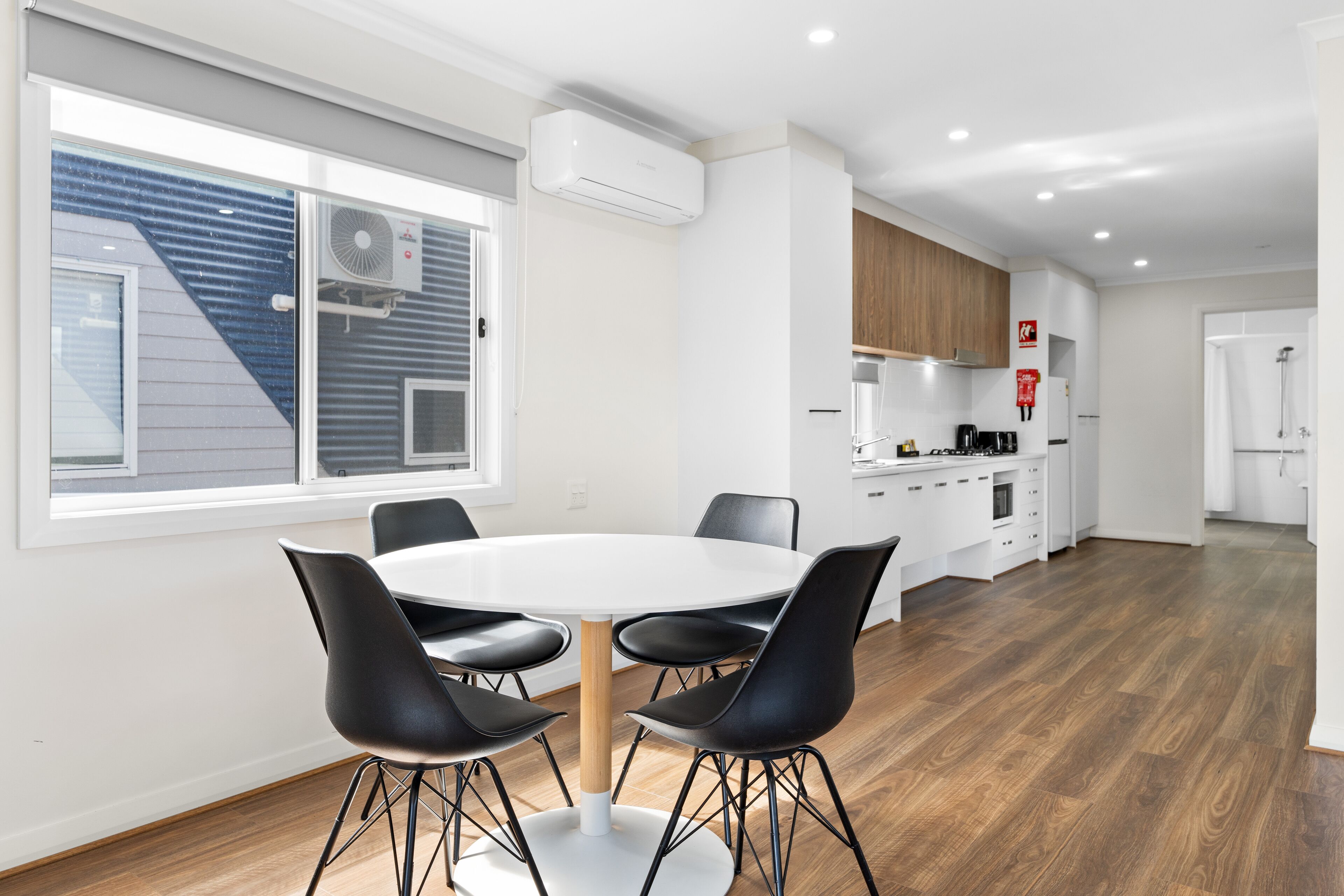 A modern kitchen with white cabinets, a wooden countertop, and a built-in oven.