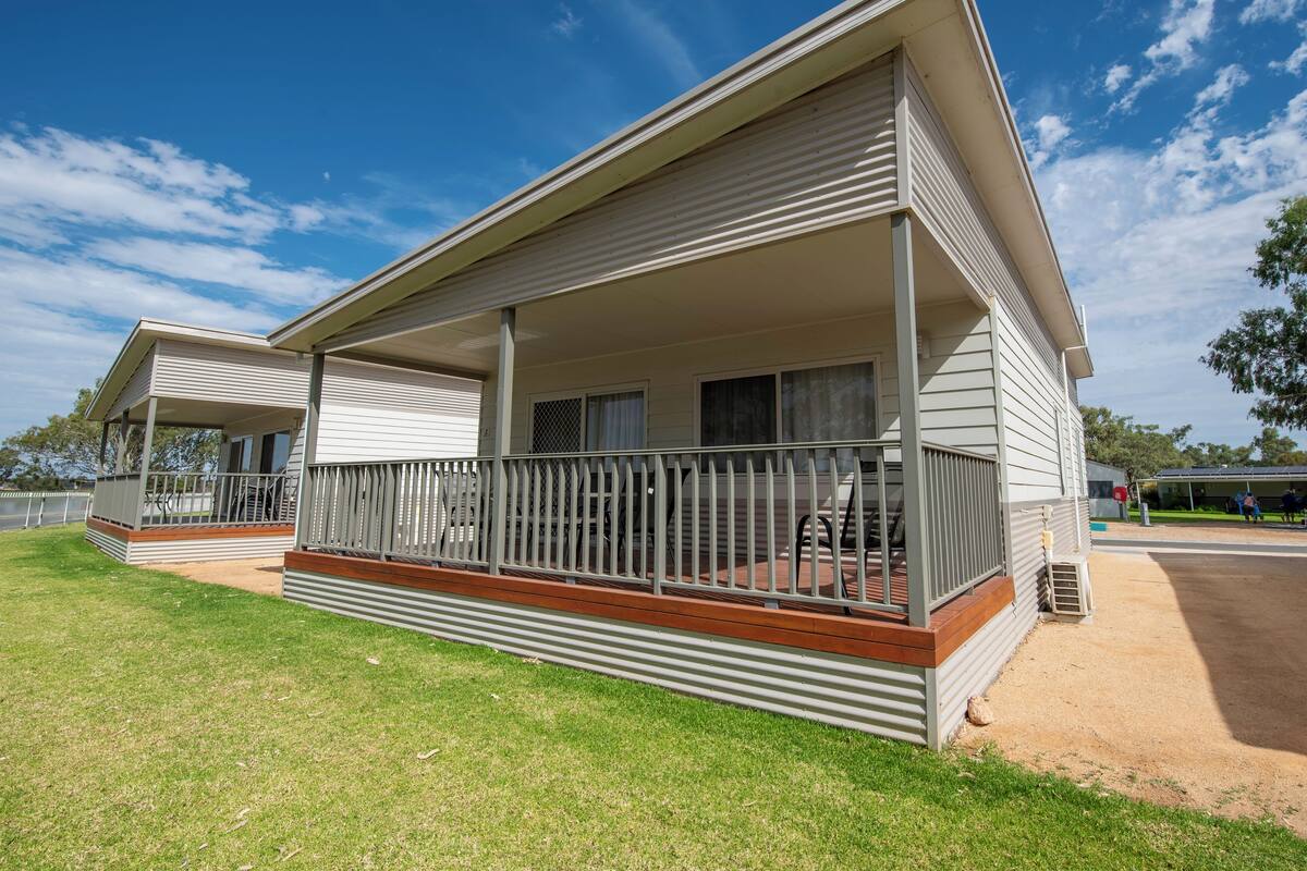 A two-story motel with a covered porch and a fenced deck area.