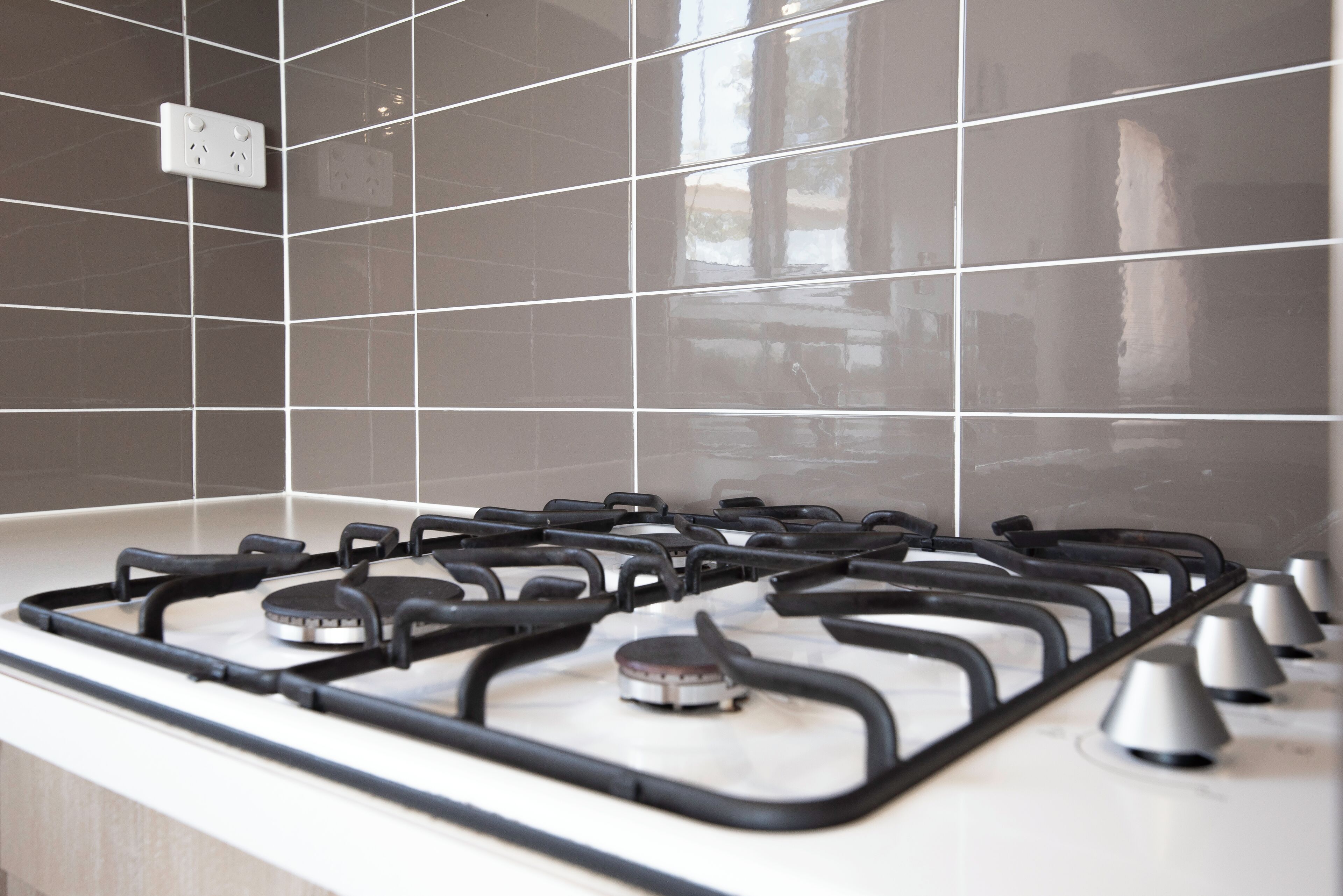 A kitchen with a gas stove and a tiled backsplash.