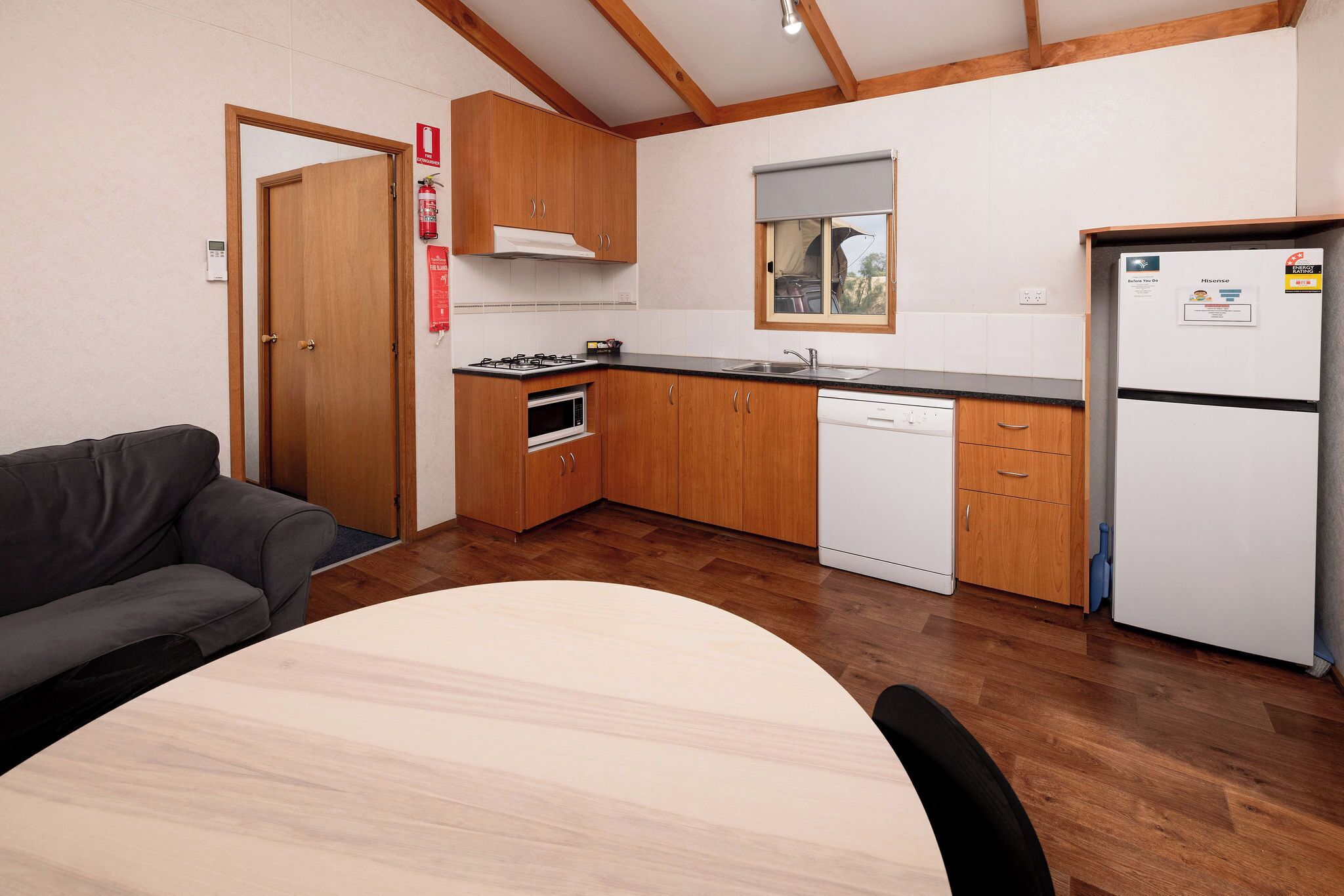 A kitchen with wooden cabinets, a stove, a sink, and a refrigerator.