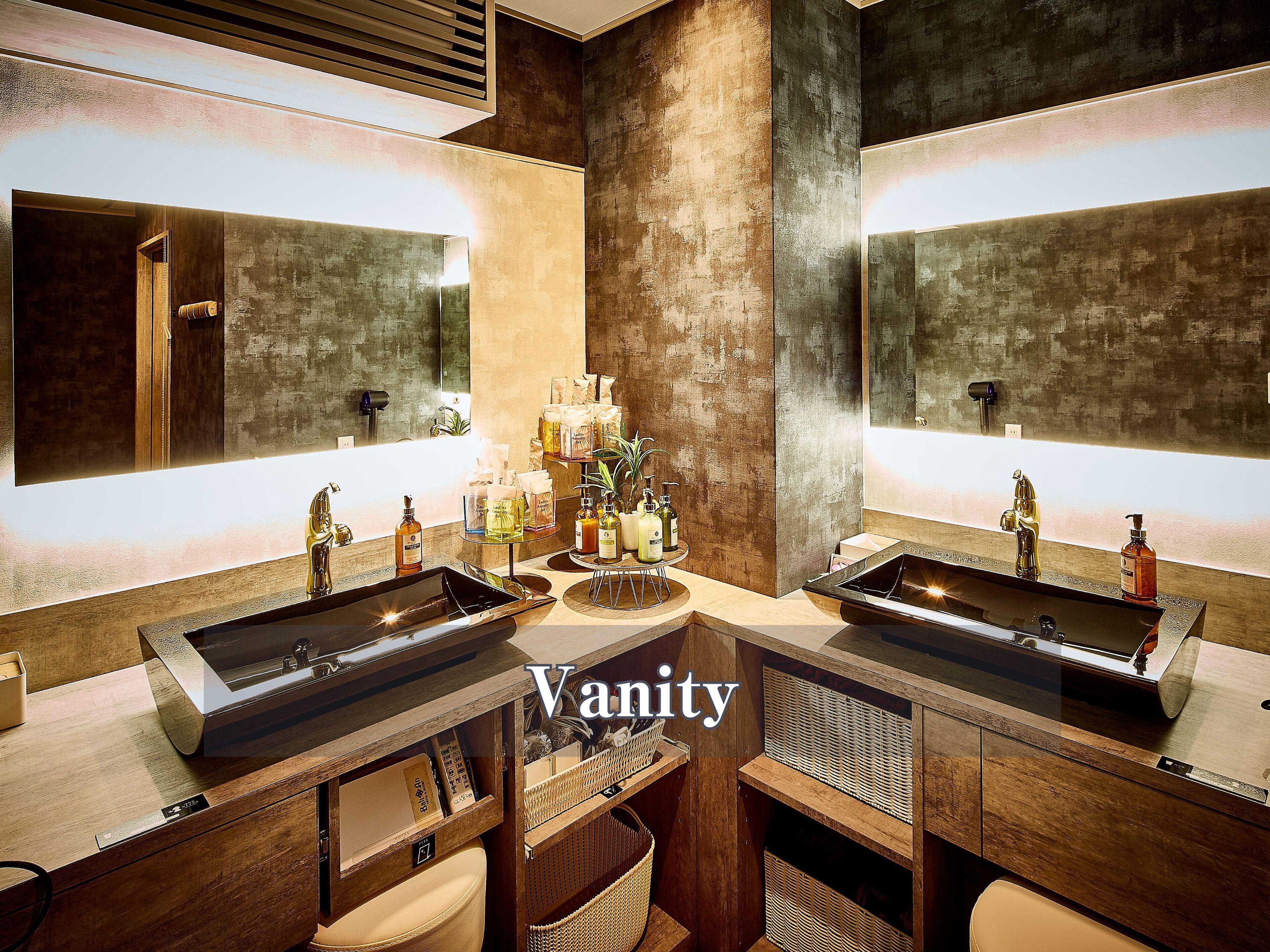 A modern bathroom with two sinks, a vanity with storage, and a large mirror.
