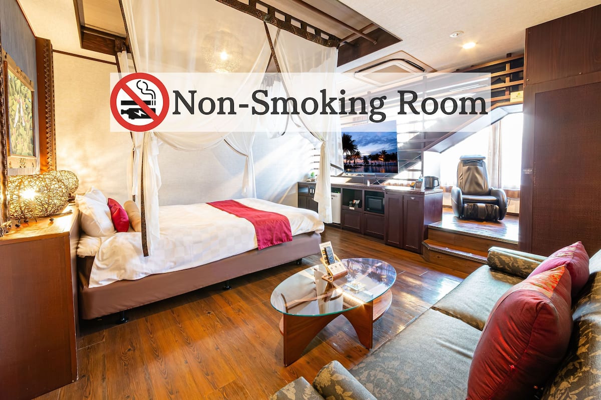 Ein Nichtraucherzimmer mit Bett, Sofa und Glastisch.